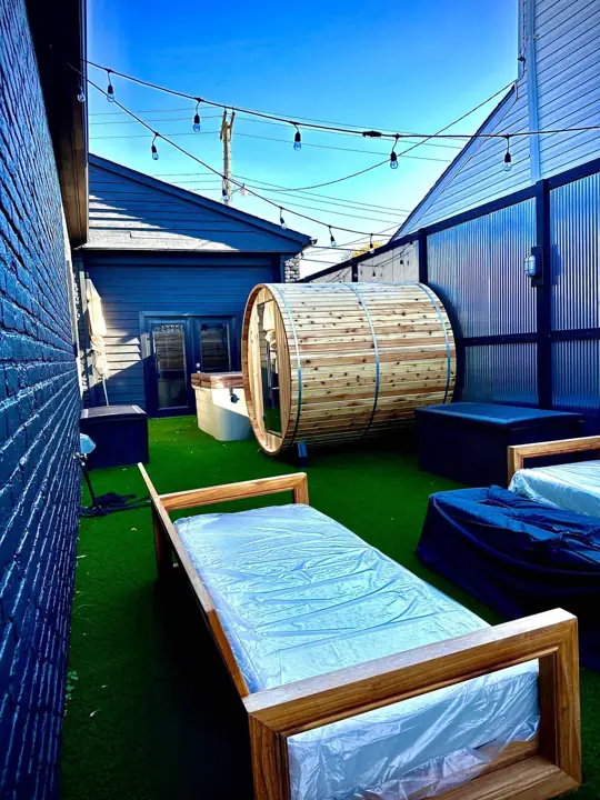 Backyard with barrel sauna and lounge chairs